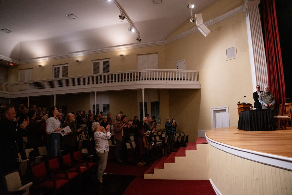 photo of crowd, standing ovation, two people on stage